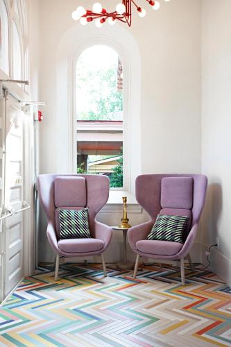 two purple chairs in a room with a window at The Russell in Nashville