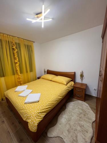 a bedroom with a yellow bed with two dishes on it at STAN NA DAN MILA in Irig