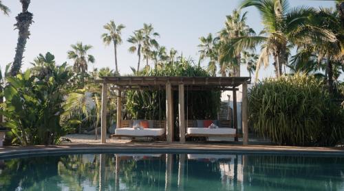a swimming pool with a gazebo next to a resort at La Poza Boutique Hotel and Spa - Adults 15 plus in Todos Santos