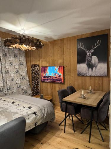 een slaapkamer met een bed en een tafel met stoelen bij Cocon au cœur de Chamonix avec parking gratuit in Chamonix-Mont-Blanc