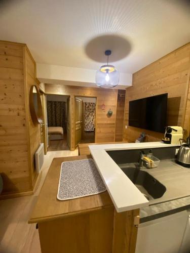 a kitchen with a sink and a living room at Appartement Cosy centre station in Vénosc