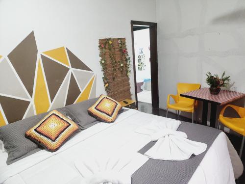 a bedroom with a white bed with pillows on it at Hostel Lumaria 1 in Blumenau