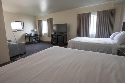 a hotel room with two beds and a television at Cobblestone Hotel & Suites-Sheldon in Sheldon