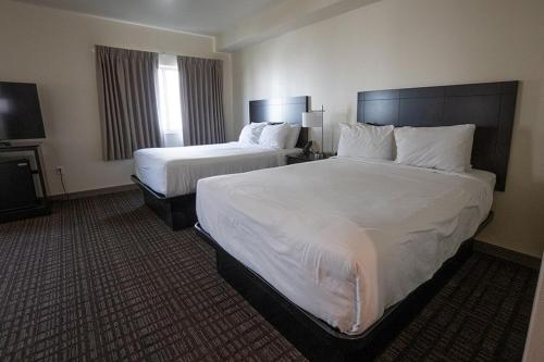 a hotel room with two beds and a television at Cobblestone Hotel & Suites-Sheldon in Sheldon