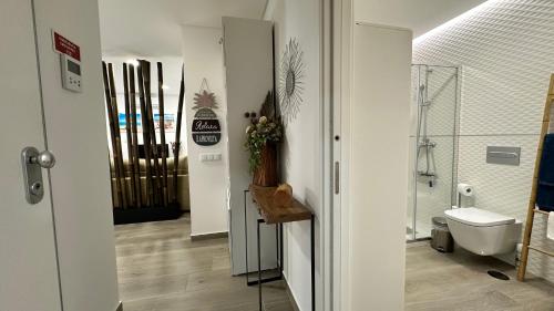 - un couloir avec une salle de bains pourvue de toilettes et d'un lavabo dans l'établissement Cristal House 250 meters from Monte Gordo beach, à Monte Gordo