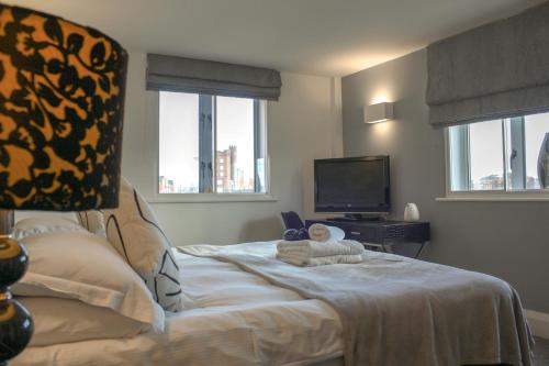 ヨークにあるMerchants Place Apartmentのベッドルーム1室(ベッド1台、テレビ、窓付)