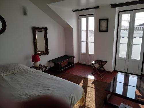 1 dormitorio con cama y espejo en la pared en Great duplex in historical center, en Lisboa