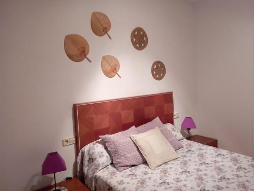 1 dormitorio con 1 cama con sombreros en la pared en casa rural El Burrillo en Cuenca