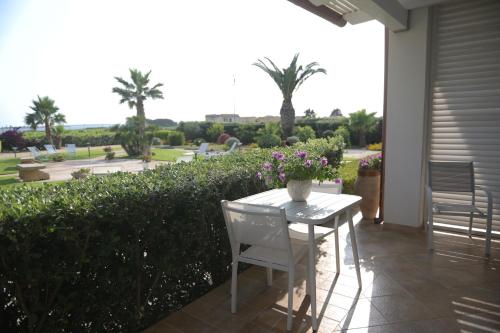 a table and chairs on a patio with a view of a garden at BdL Open Space in Marsala