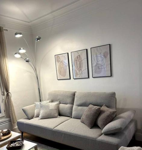 a living room with a couch and four pictures on the wall at appartement in Vitry-sur-Seine