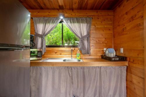 una cocina con fregadero y una ventana en una cabaña en Cabaña El Ciprés: Vistas increíbles y Mirador en Turrialba