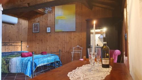 a room with a bed and a table with a bottle of wine at Casa Puggimiano in Poggio Moiano