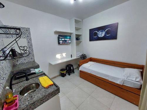 a small bedroom with a bed and a sink at Confortáveis e práticas Kitnets em Belo Horizonte in Venda Nova