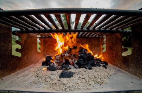 a fire inside of a brick oven with flames at Explore Maui's diverse campgrounds and uncover the island's beauty from fresh perspectives every day as you journey with Aloha Glamp's great jeep equipped with a rooftop tent in Paia