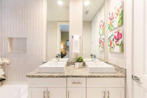 a bathroom with two sinks and a large mirror at LOCATION!! Modern Luxury Home 2 miles from Disney! in Orlando