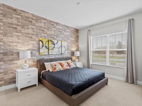 een slaapkamer met een bakstenen muur en een bed met kussens bij LOCATION!! Modern Luxury Home 2 miles from Disney! in Orlando