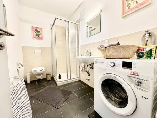 een badkamer met een wasmachine en een wastafel bij Stylisches Studio mit privatem Stellplatz wenige Minuten von der Innenstadt & Mosel in Koblenz