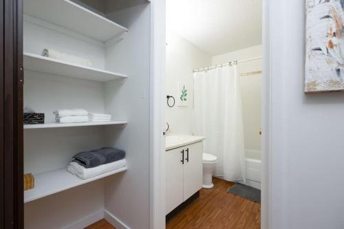 a white bathroom with a sink and a toilet at Newly Renovated 2BR with Parking and Near NLRHC in Fort McMurray