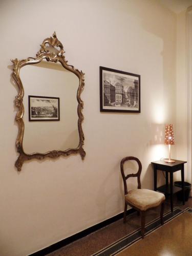 a mirror on a wall with a chair and a table at B&B Genova Centro in Genova