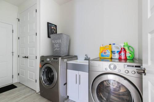 a laundry room with a washing machine and a washer at Comfortable Lux, Sleeps 10, PingPong, Movie Room in London