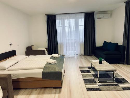 1 dormitorio con 1 cama grande y 1 sofá en M&F Apartman, en Egerszalók