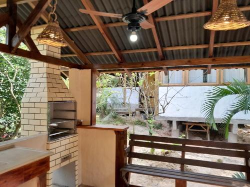 een buitenkeuken met een plafondventilator en een grill bij Recanto das Bromélias Chalés in Guarda do Embaú