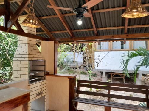 an outdoor kitchen with a ceiling fan and a grill at Recanto das Bromélias Chalés in Guarda do Embaú