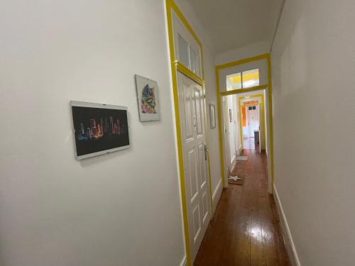 a hallway with two pictures on the wall and a door at Owls Hostel Ildefonso in Porto