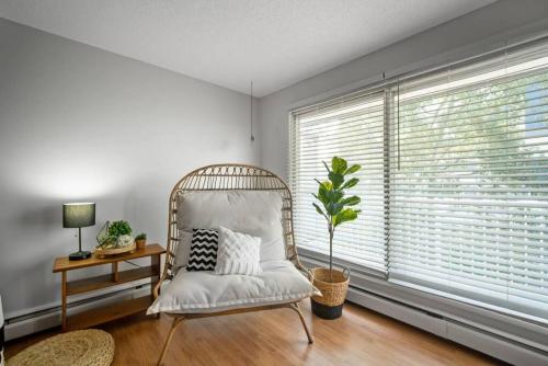 a white chair in a room with a window at Downtown 1BR Top Floor with View Free Parking in Fort McMurray