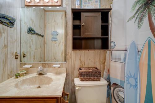 a bathroom with a sink and a toilet and a mirror at Outer Banks Retreat - Walk to Beach! in Southern Shores