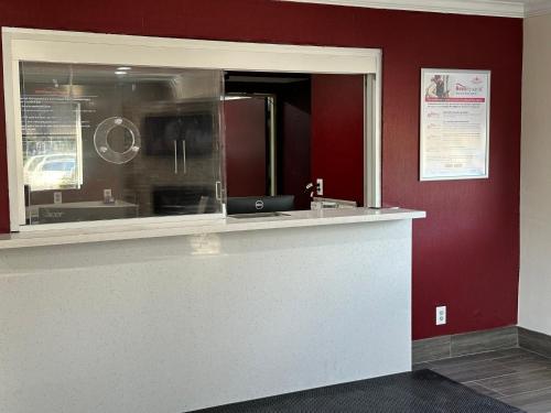 a kitchen with a counter and red walls at Red Roof Plus Belleville in Belleville