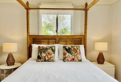 a bedroom with a large bed with two lamps at Beachmere Palms Motel in Beachmere