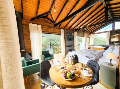 - une chambre avec un lit, une table et des chaises dans l'établissement Chalé Canto da Montanha, à Annitapolis