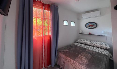 1 dormitorio con 1 cama y una ventana con cortinas rojas en Playa Coronado - piscine - Golf., en Playa Coronado