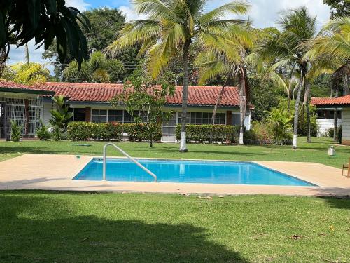 a swimming pool in front of a house with palm trees at Playa Coronado - piscine - Golf. in Playa Coronado