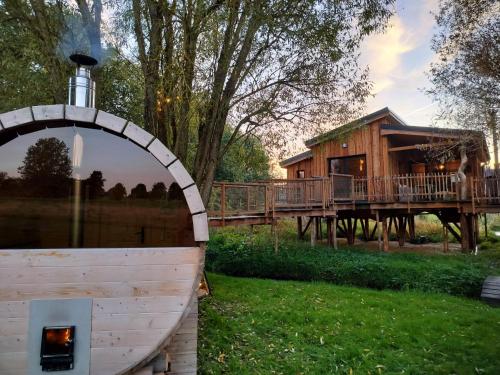 a log cabin with a fire place in the grass at La Cabane d'Ode in Sainte-Ode