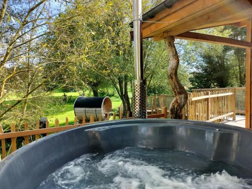 a hot tub in a backyard with a gazebo at La Cabane d'Ode in Sainte-Ode