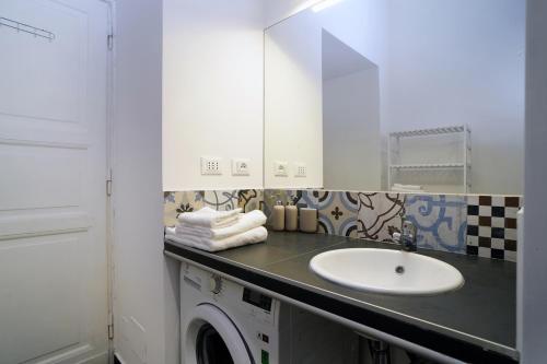 uma casa de banho com um lavatório e uma máquina de lavar roupa em La Casa Romana em Roma