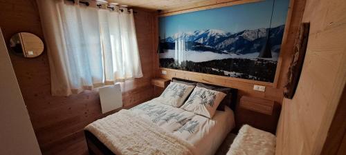1 dormitorio con 1 cama y una foto en la pared en Bas de châlet Noémaé, en Eyne