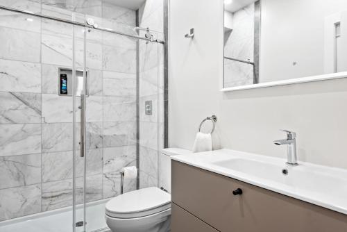 een badkamer met een douche, een toilet en een wastafel bij 4bdr/4bth penthouse with roof terrace in Washington