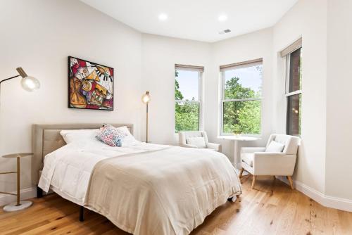 een witte slaapkamer met een bed en een stoel bij 4bdr/4bth penthouse with roof terrace in Washington
