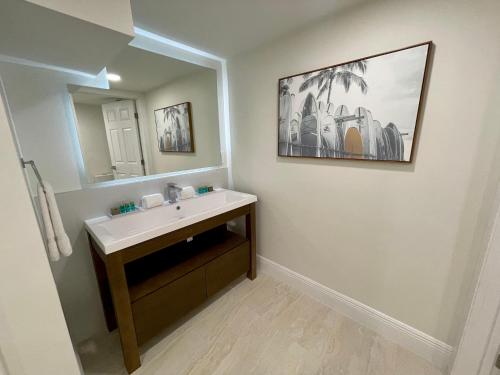 uma casa de banho com um lavatório e um espelho em Melbourne Beach Resort em Melbourne Beach