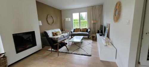 sala de estar con sofá y TV en Villa 4ch jardin proche de Lille, en Bondues
