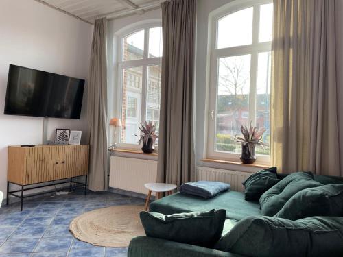een woonkamer met een bank en een groot raam bij Ferienwohnung Lavendel in Butjadingen