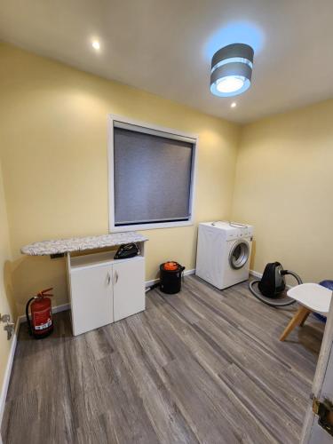 a laundry room with a washer and dryer and a window at Cabañas Pewmawapi in Quellón