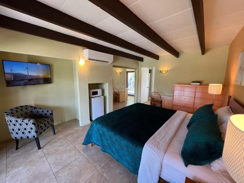 a bedroom with a large bed and a kitchen at Vista Grande Resort - A Gay Men's Resort in Palm Springs