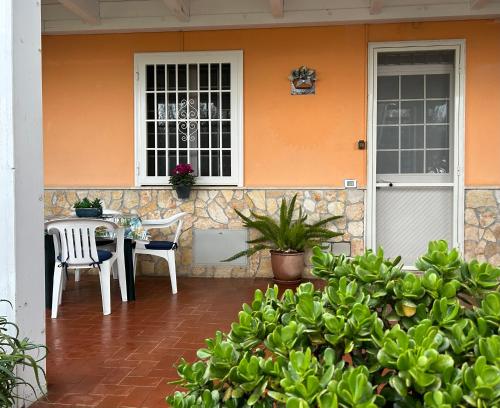 un patio con tavolo e sedie di fronte a una casa di Demetra Apartment Sperlonga a Sperlonga