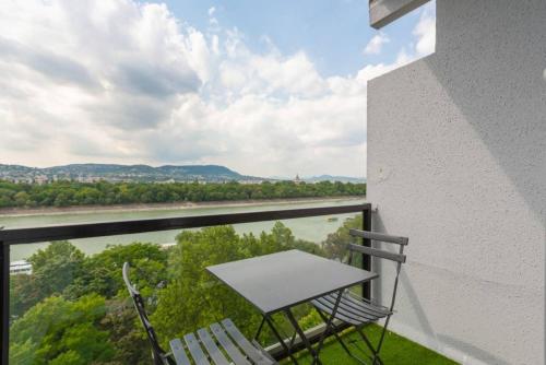 a table and two chairs on a balcony with a view at Sunny Hotel Home with An Unbeatable Balcony View in Budapest