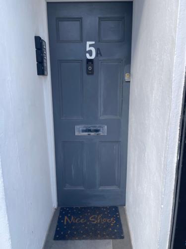 Una puerta azul con el número. en Quela’s comfort en Londres