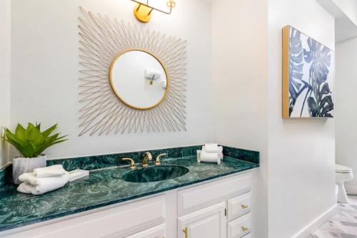 La salle de bains est pourvue d'un lavabo et d'un miroir. dans l'établissement Mermaid Manor - Anna Maria, FL, à Anna Maria
